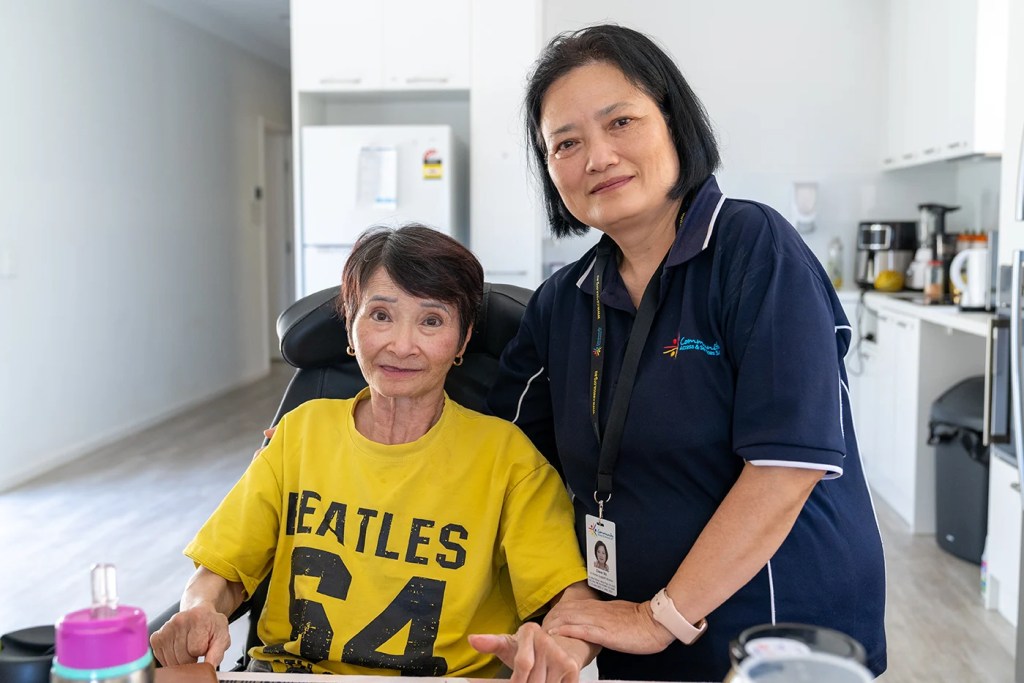 A woman being assisted by her NDIS carer. Both are from multicultural backgrounds.